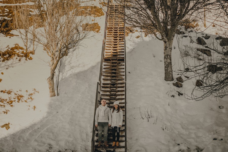 preboda en la nieve, pareja en una escalera de madera