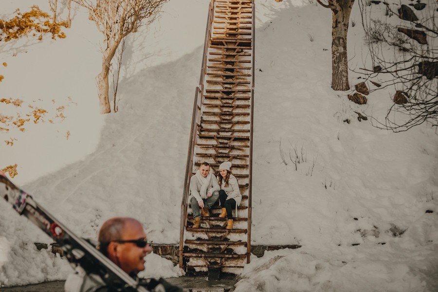 preboda en la nieve, pareja en una escalera de madera