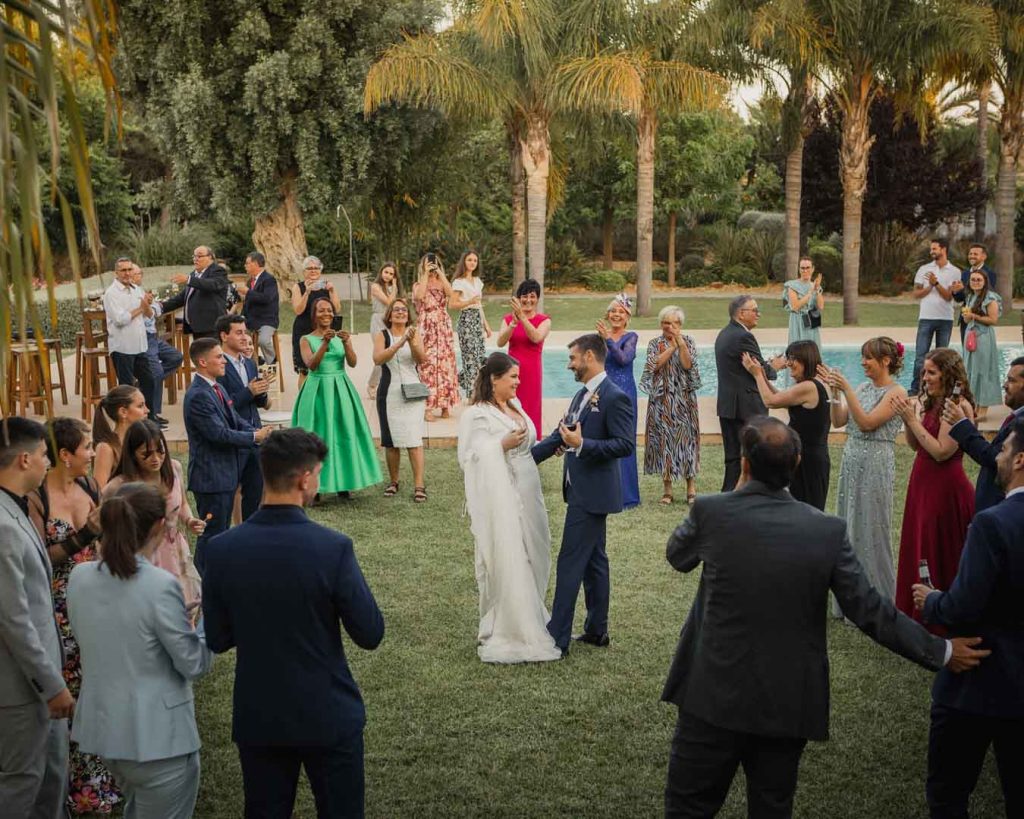 invitados rodean a los novios bailando