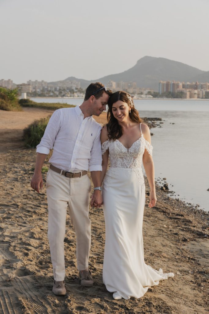 Couple ater the ceremony walking on the sunset on the beach